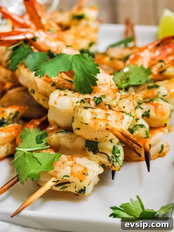 Spicy Grilled Shrimp served on a white platter with lime wedges.