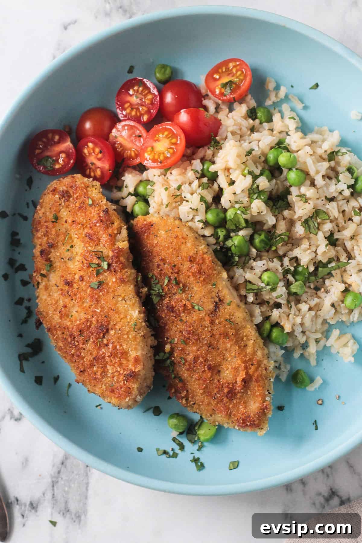 Close up of crispy breaded cutlets on a bed of rice.