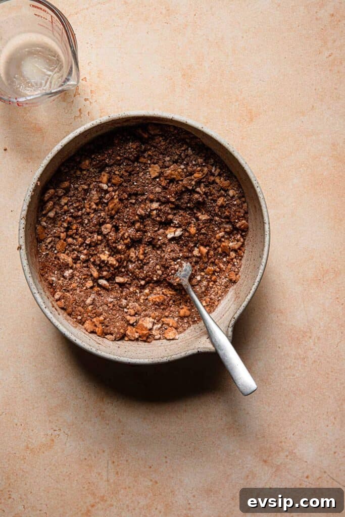 Israeli Chocolate Truffles Recipe — Classic No-Bake Treat 5 A ball with cookie mixture with a fork. A measuring cup next to it.