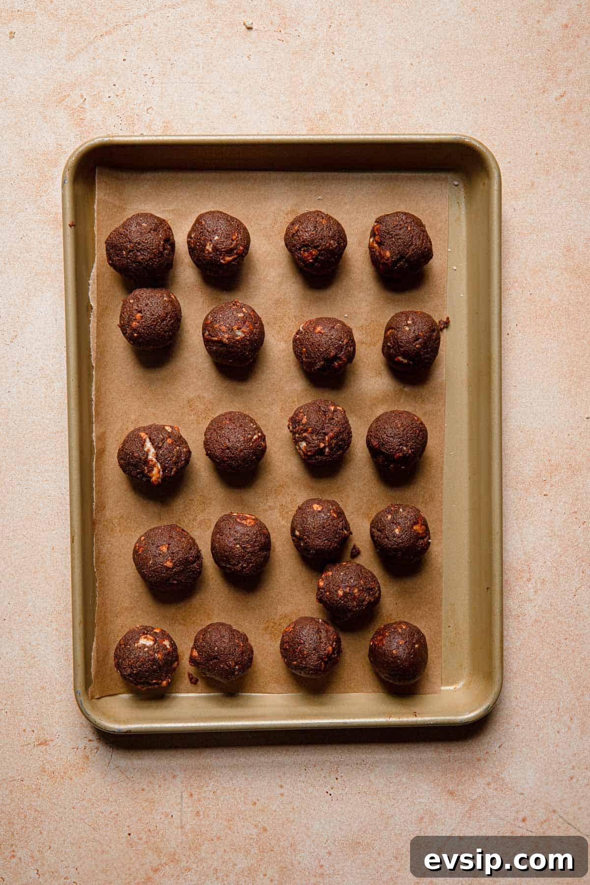 Israeli Chocolate Truffles Recipe — Classic No-Bake Treat 8 Chocolate cookie balls over a tray lined with parchment paper.