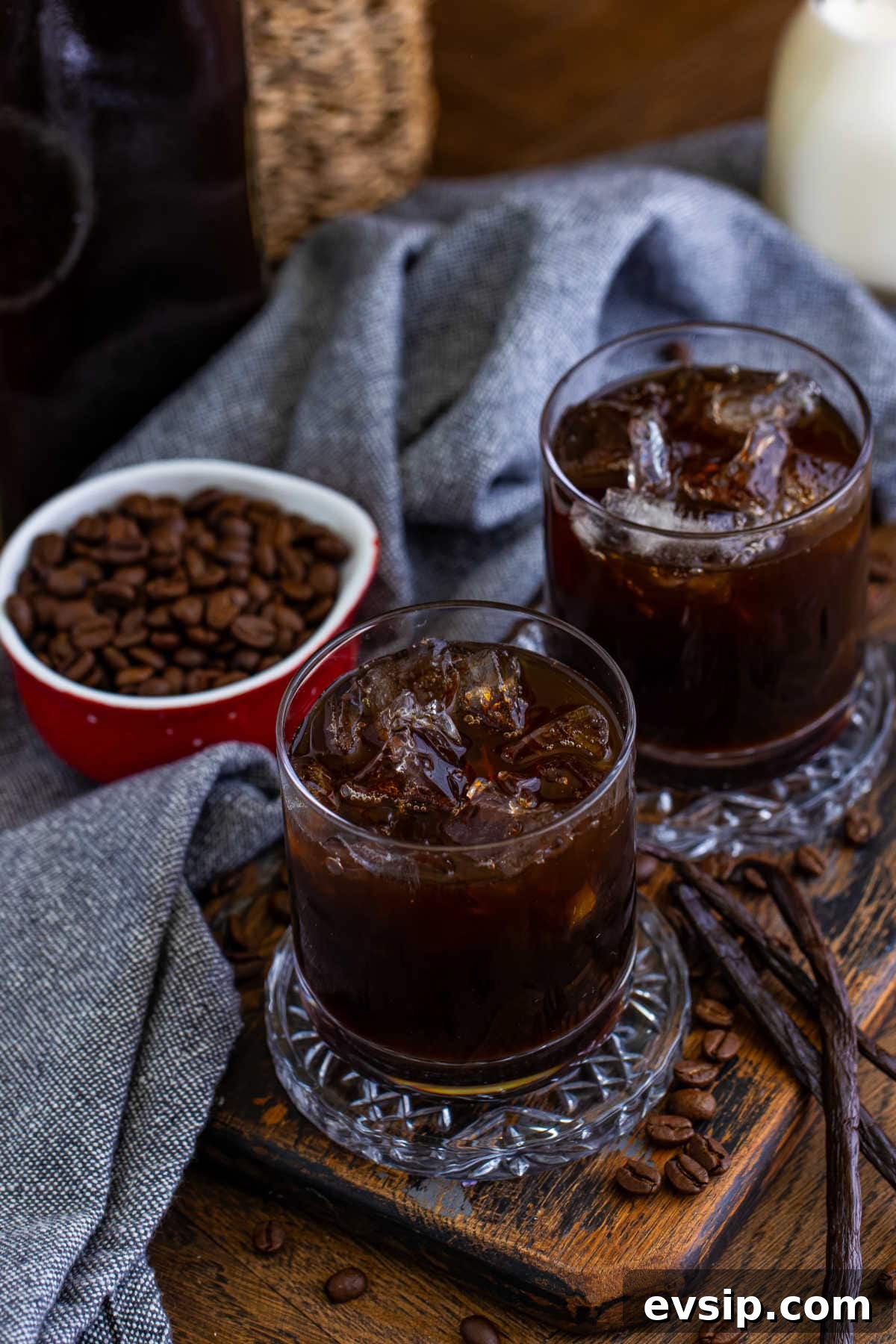 Homemade Kahlúa Liqueur Recipe: How to Make Coffee Vodka Liqueur 6 Glasses of the recipe surrounded by coffee beans and vanilla beans.