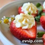 cheesecake stuffed strawberry with a daisy on a white plate