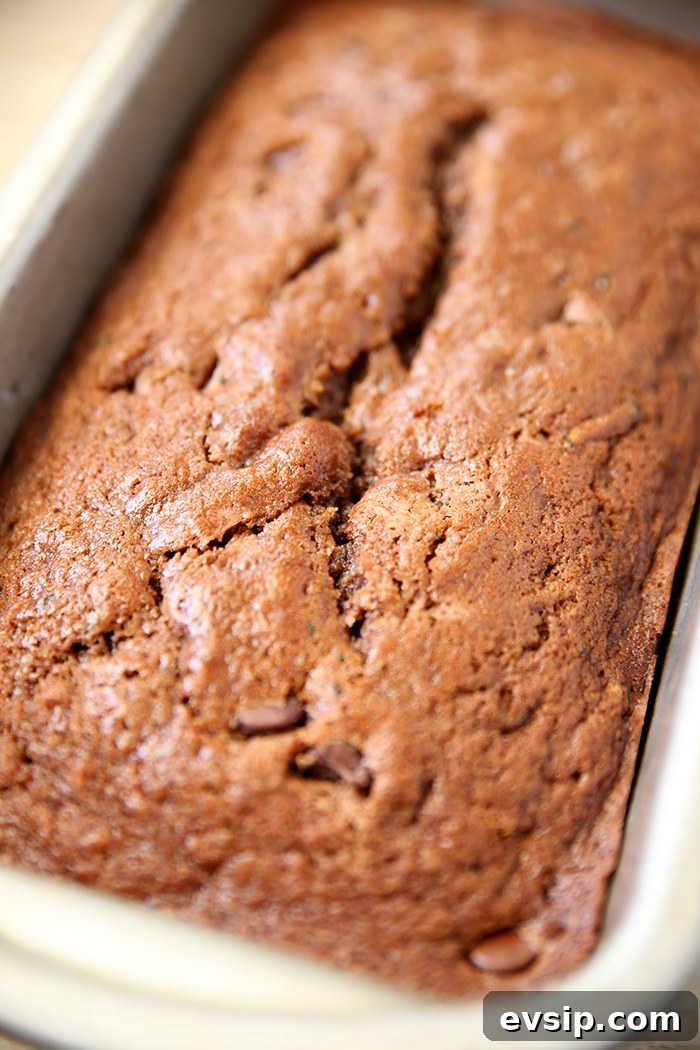 A loaf of chocolate zucchini bread in a stone loaf pan.