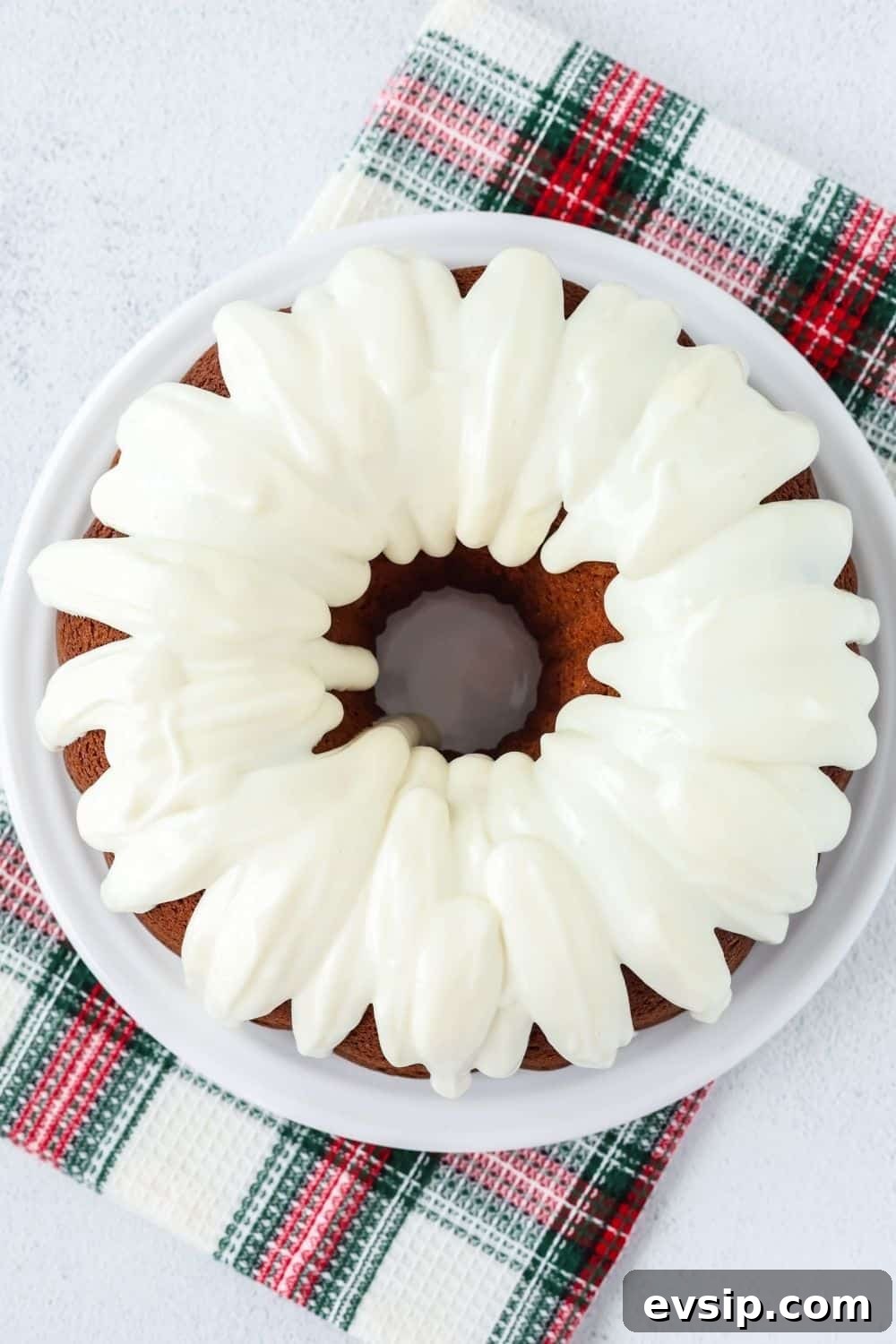 overhead view of cream cheese icing drizzled over a gingerbread bundt cake made from a box of cake mix.