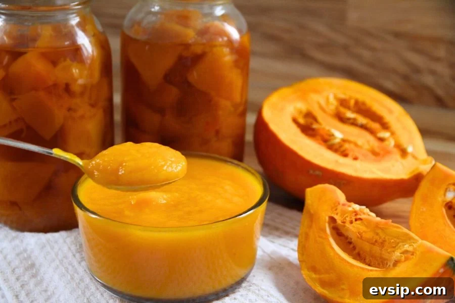 A bowl of homemade pumpkin puree in front of home canned jars of pumpkin cubes.