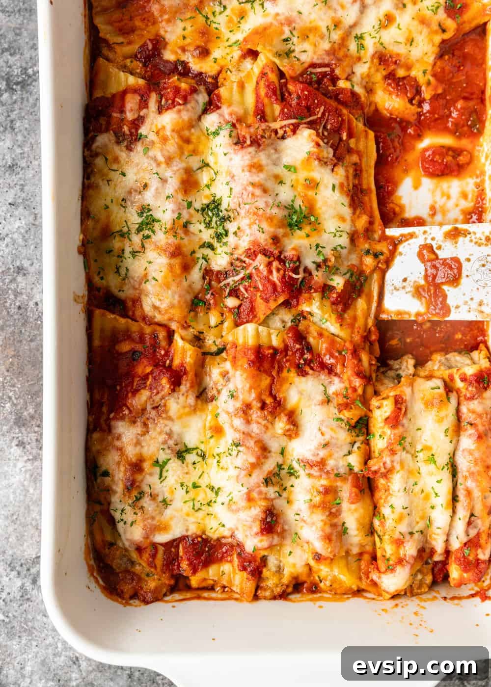 Cheesy Beef Manicotti Recipe with Homemade Marinara 8 overhead: a baking dish full of baked manicotti with sauce and cheese on top