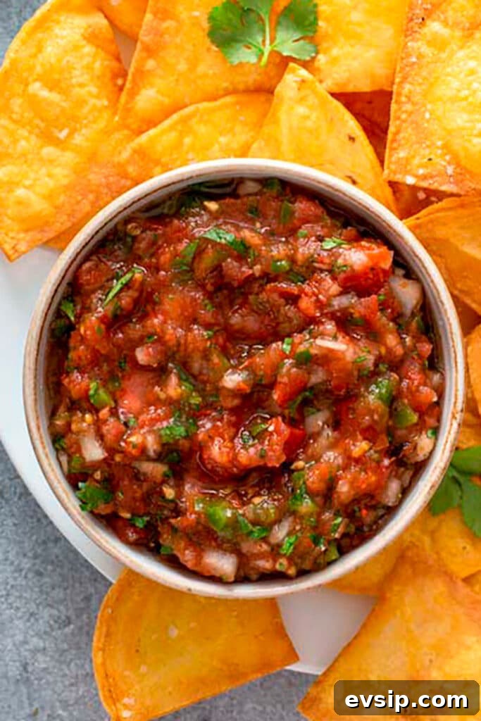 Top view of a bowl of fresh Mexican Salsa with homemade tortilla chips 