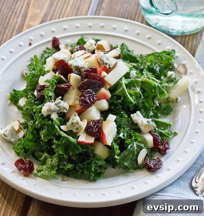 Refreshing Apple & Kale Power Salad topped with tart cherries, almonds, blue cheese, and perfectly dressed with apple maple vinaigrette!