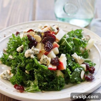 Refreshing Apple & Kale Power Salad topped with tart cherries, almonds, blue cheese, and perfectly dressed with apple maple vinaigrette!