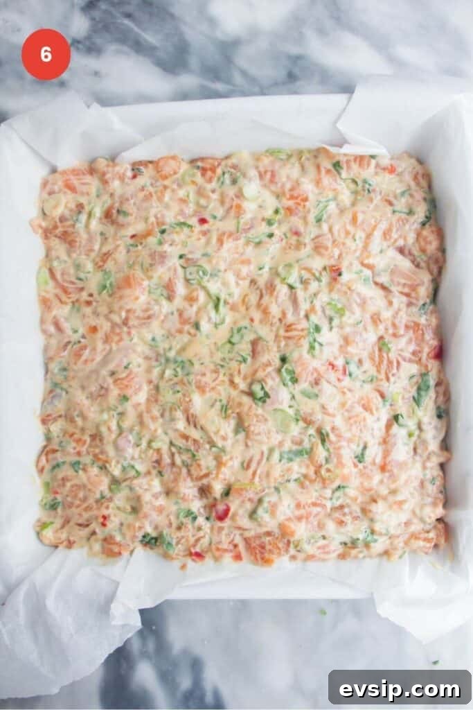 Salmon mixture smoothed onto nori sheet in a baking dish.