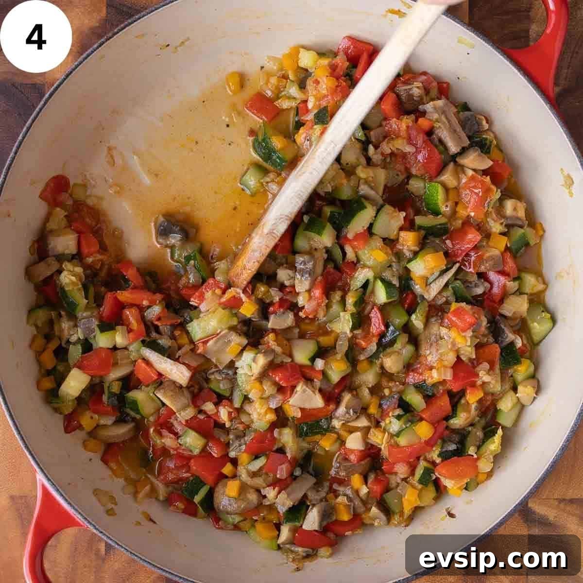 Stirring a cooked mixture of vegetables in a skillet.