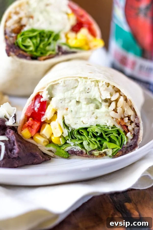 Ranch Chicken Avocado Bacon Burritos are an easy to prepare meal made with shredded chicken that is slathered in an avocado ranch crema, crispy bacon, cheese, tomatoes, corn, refried beans, rice, and lettuce. It is some of the best foods that have brought together in one amazing burrito.