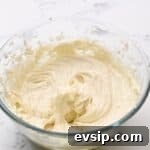 Carrot Cake Cupcakes from Box Mix — Moist, Spiced & Quick 8 beaten cream cheese frosting in a glass bowl.