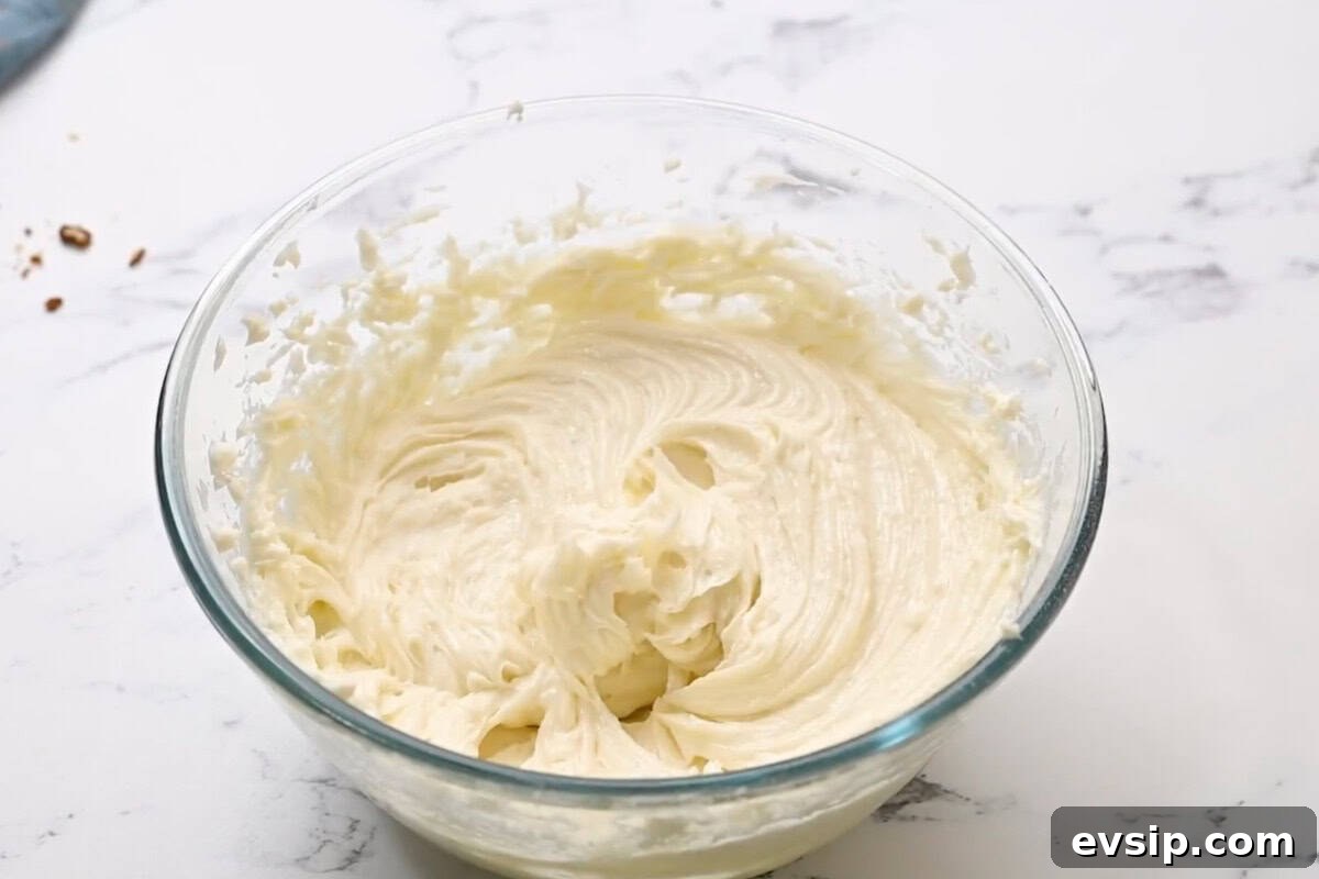 Carrot Cake Cupcakes from Box Mix — Moist, Spiced & Quick 13 beaten cream cheese frosting in a glass bowl.