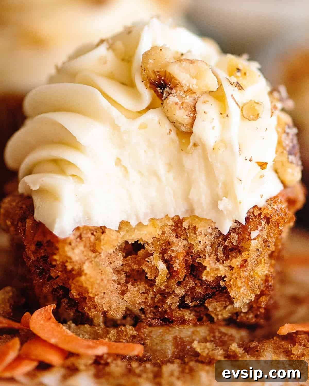 Carrot Cake Cupcakes from Box Mix — Moist, Spiced & Quick 3 an unwrapped and bitten carrot cake cupcake.
