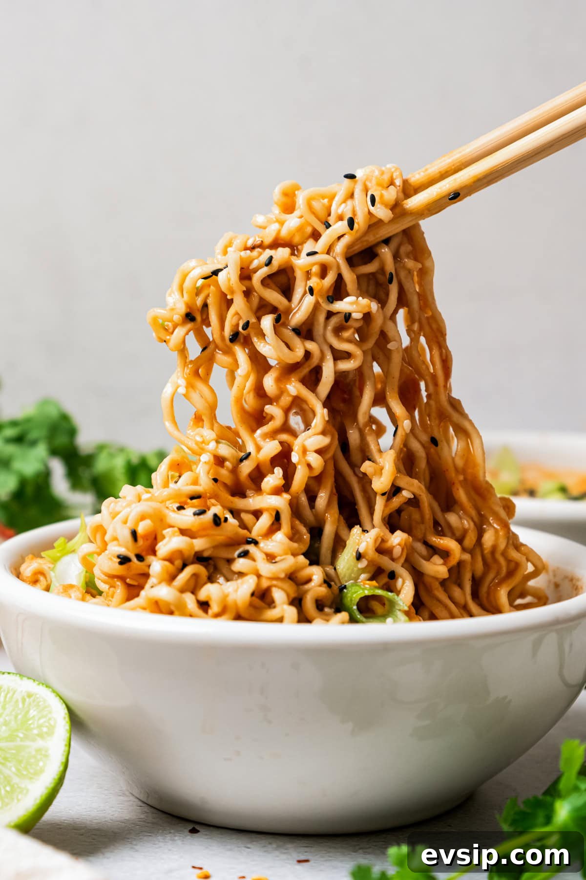 Chopsticks holding up ramen noodles.