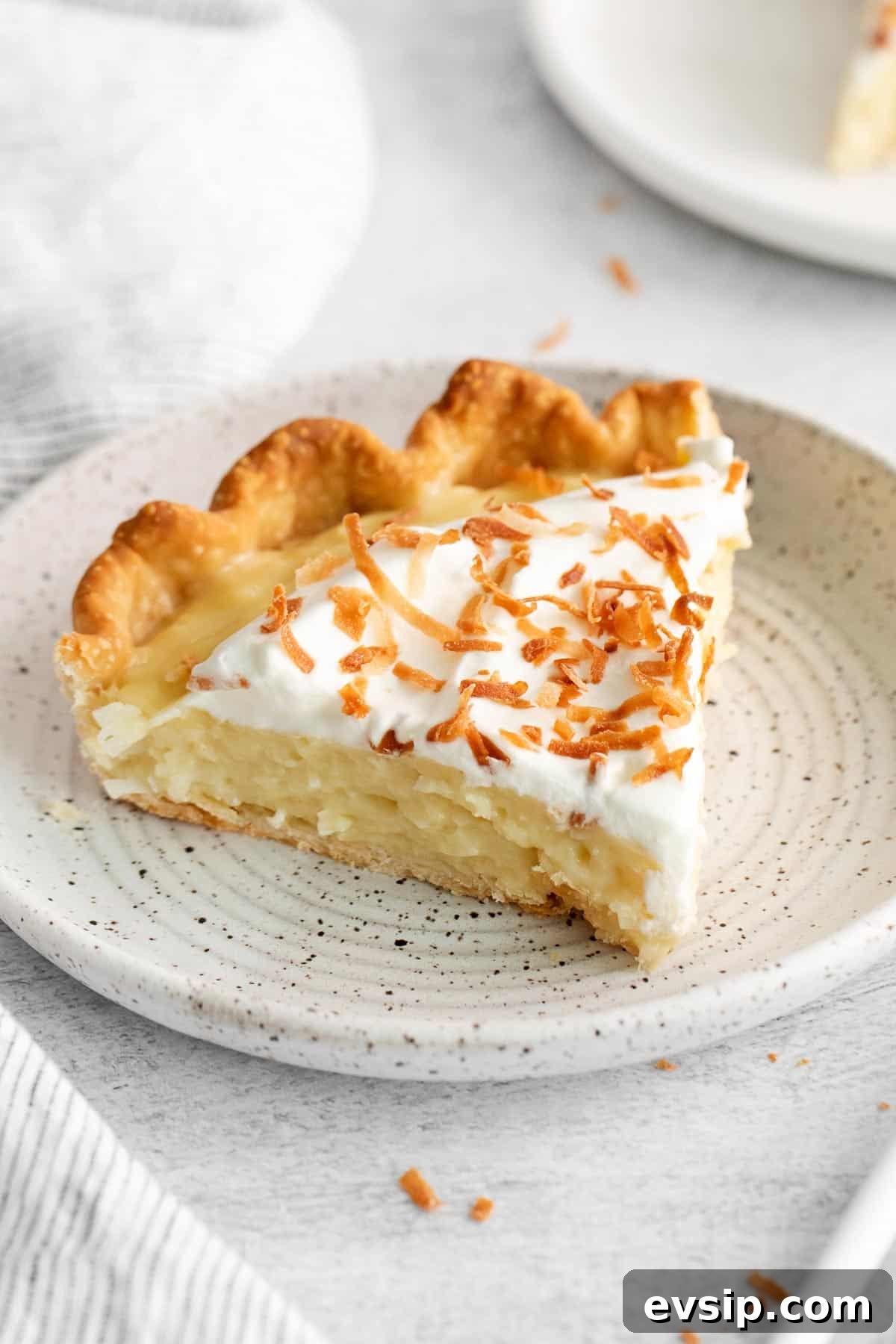 A slice of coconut cream pie on a plate