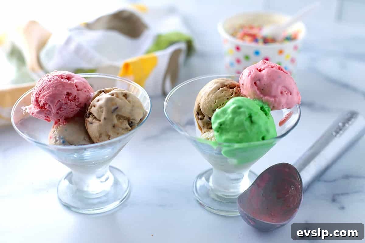 two ice cream glasses with ice cream and an ice cream scoop on the table.