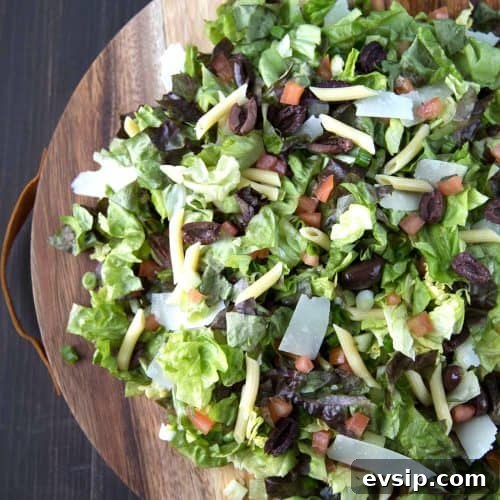 italian chopped salad on a round wooden serving platter.