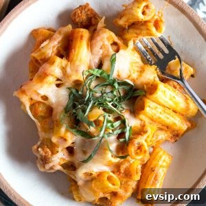 baked ziti in a cream bowl topped with basil