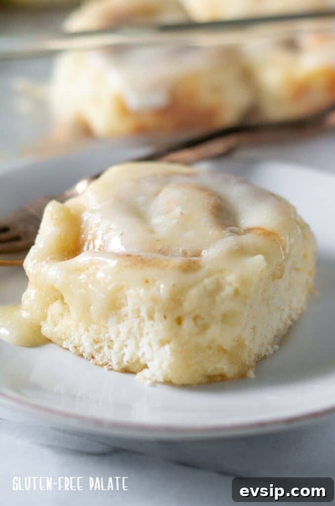Irresistible Gluten-Free Brunch Recipes You’ll Crave Again 11 A gluten-free cinnamon roll with white icing on a white plate.