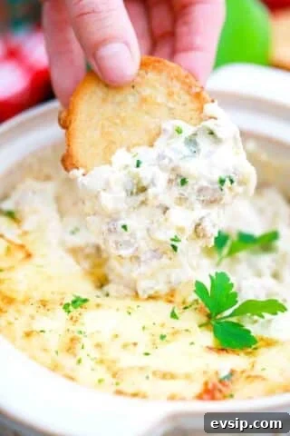 a crostini dipped into baked Philly cheesesteak dip