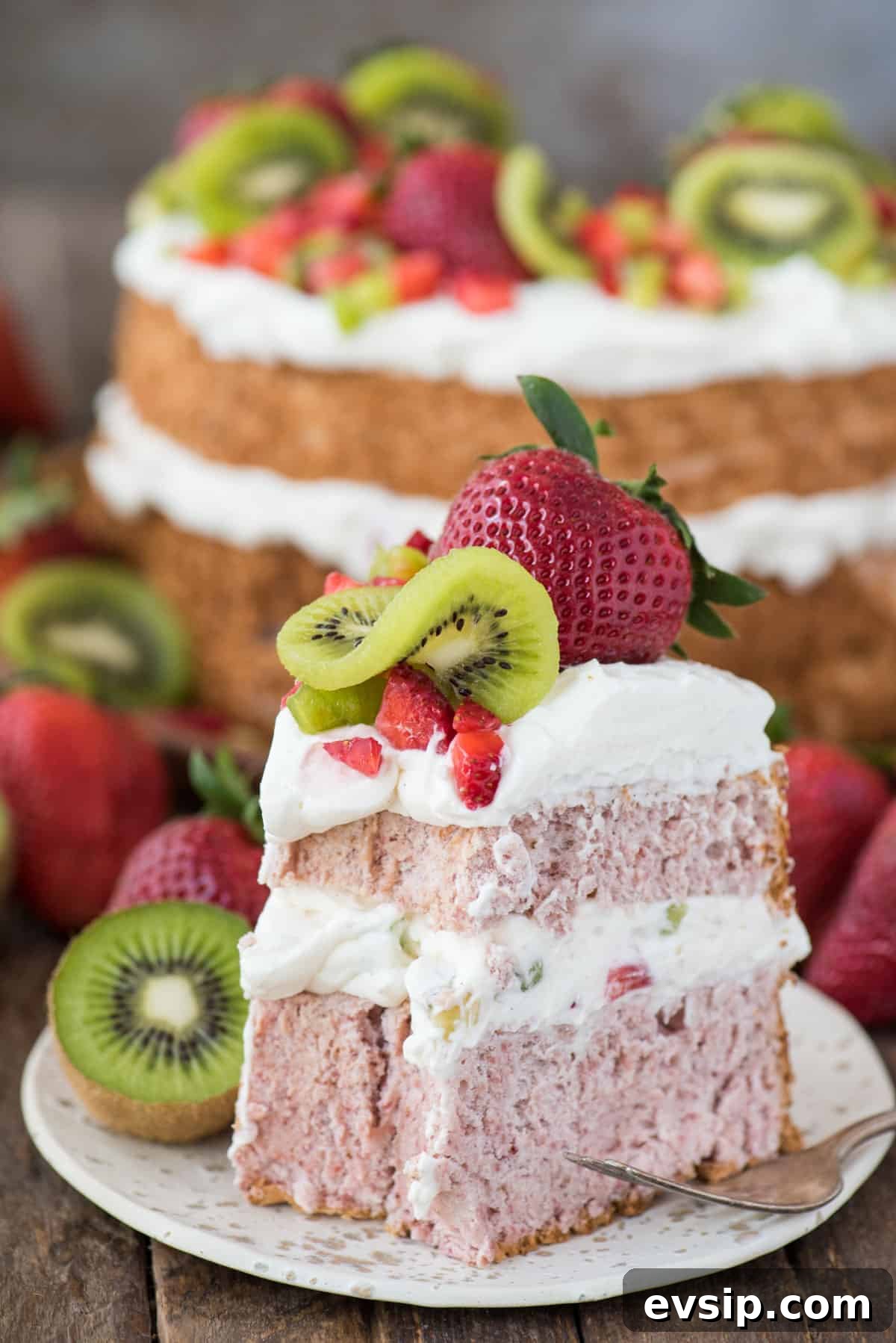 Light and Fluffy Strawberry Angel Food Cake Recipe 3 slice of strawberry angel for cake with whipped cream, strawberries and kiwi on white plate