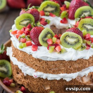 Light and Fluffy Strawberry Angel Food Cake Recipe 8 strawberry angel food cake topped with whipped cream, whole strawberries, chopped strawberries and kiwi on wooden serving tray