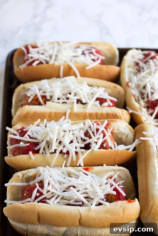 vegan meatballs subs with shredded cheese before baking.