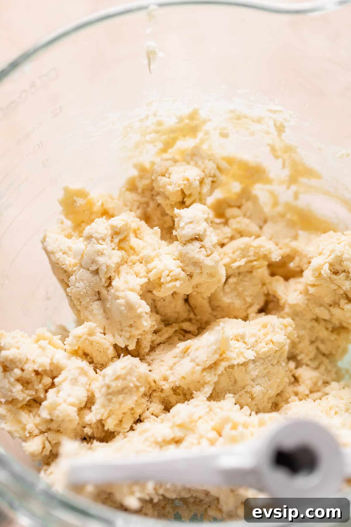 Pie dough in a mixer bowl.