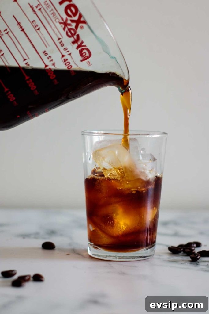 Cold Brew Coffee Concentrate: Ratios, Methods & Pro Tips 14 cold brew coffee being poured into a cup filled with ice