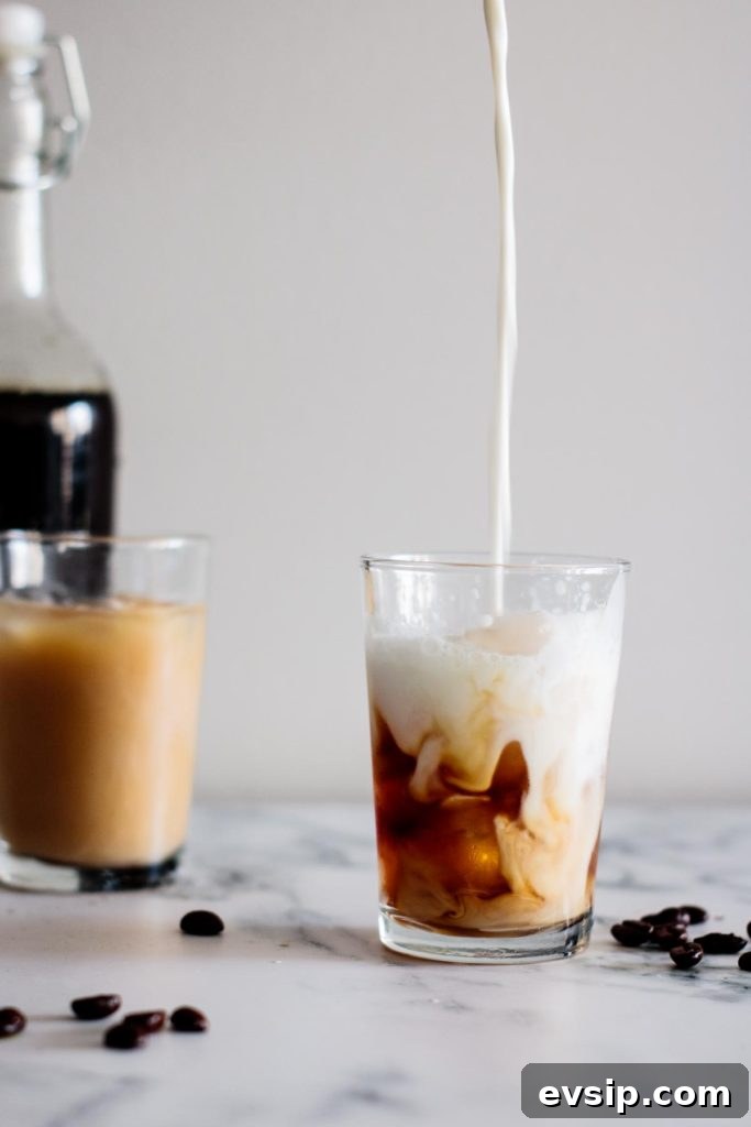 Cold Brew Coffee Concentrate: Ratios, Methods & Pro Tips 4 milk pouring into a cup, with a cup and a bottle on the background