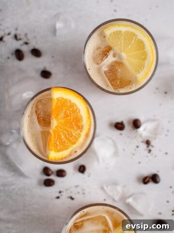 three glasses of coffee lemonade decorated with lemons and orange slices