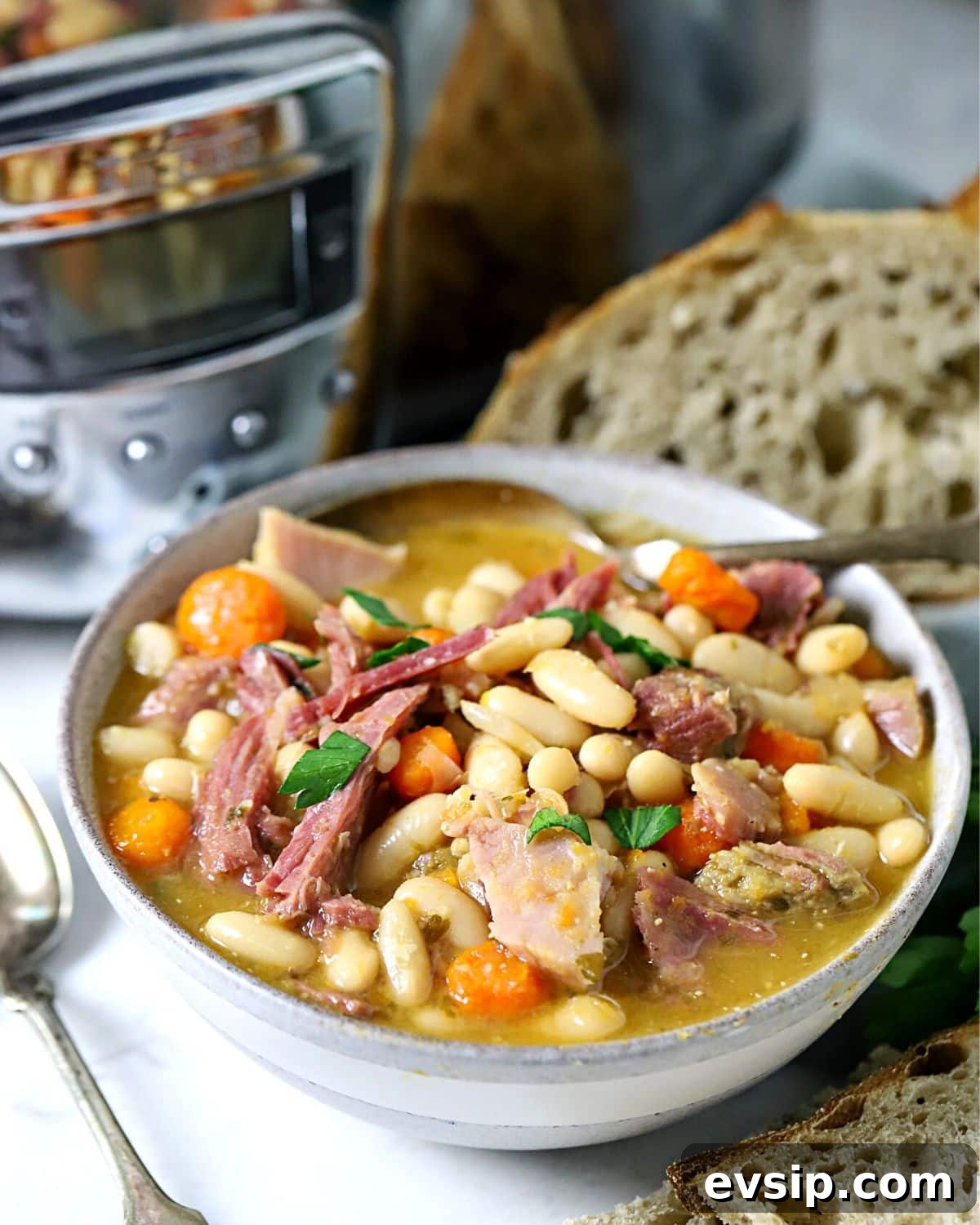 Crock pot bean soup in a bowl with a spoon in it.