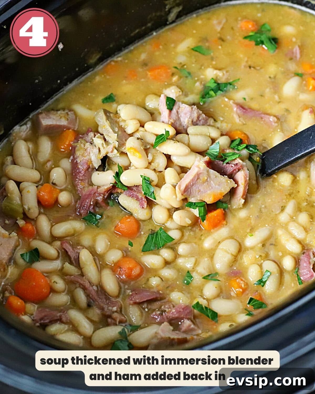 Ham and bean soup in a slow cooker with a ladle in it.