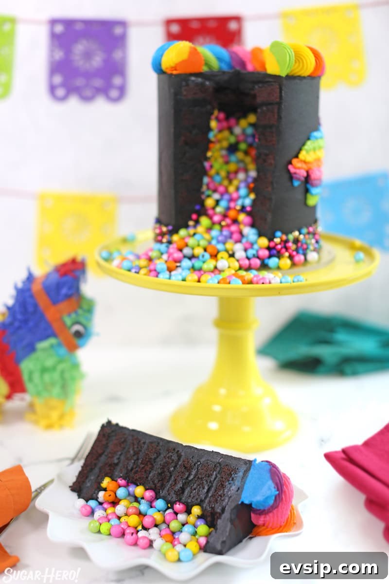Piñata Cake Recipe with Video: Step-by-Step Guide 6 Chocolate pinata cake with candy inside on a yellow cake stand with a single piece in front