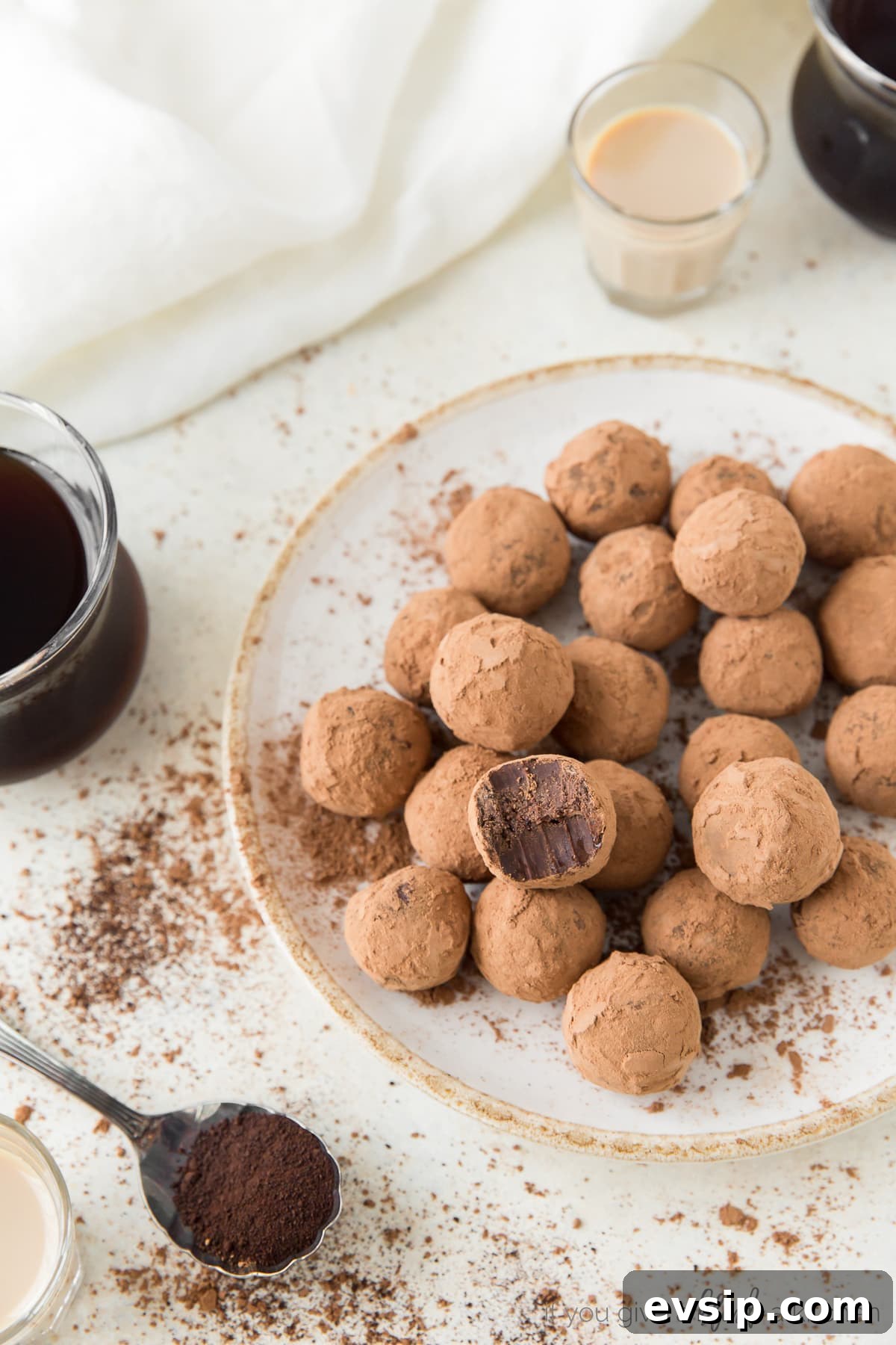 plate of cocoa covered espresso truffles; spoon of espresso and glass of coffee next to plate