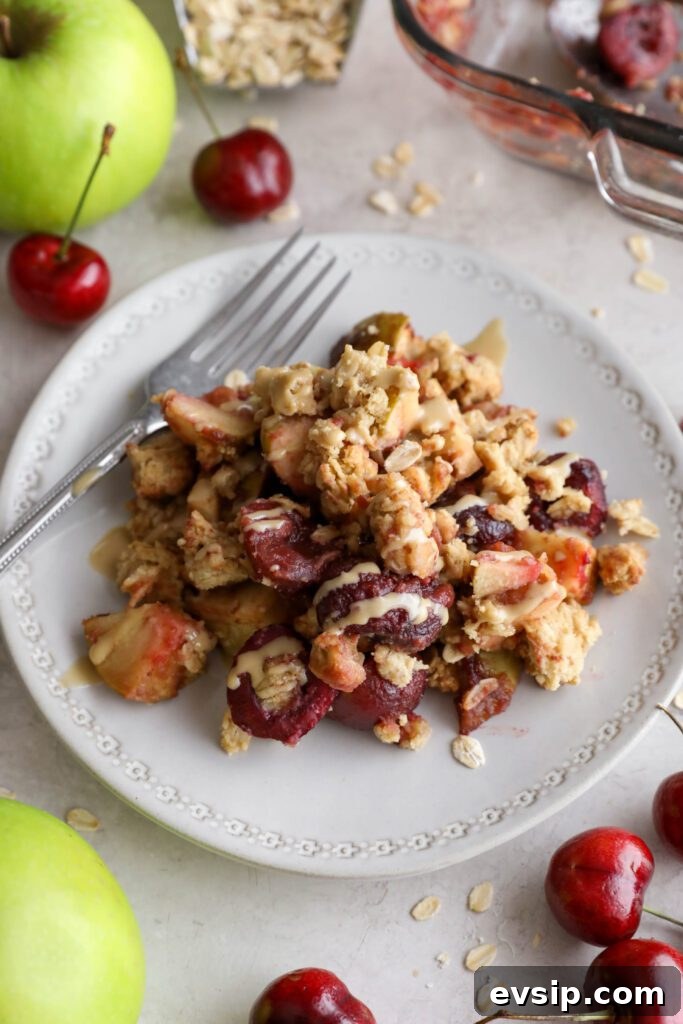 Apple Cherry Tahini Crumble Recipe — Rustic Fruit Dessert 13 Apple cherry tahini crumble served on plate surrounded by cherries and apple