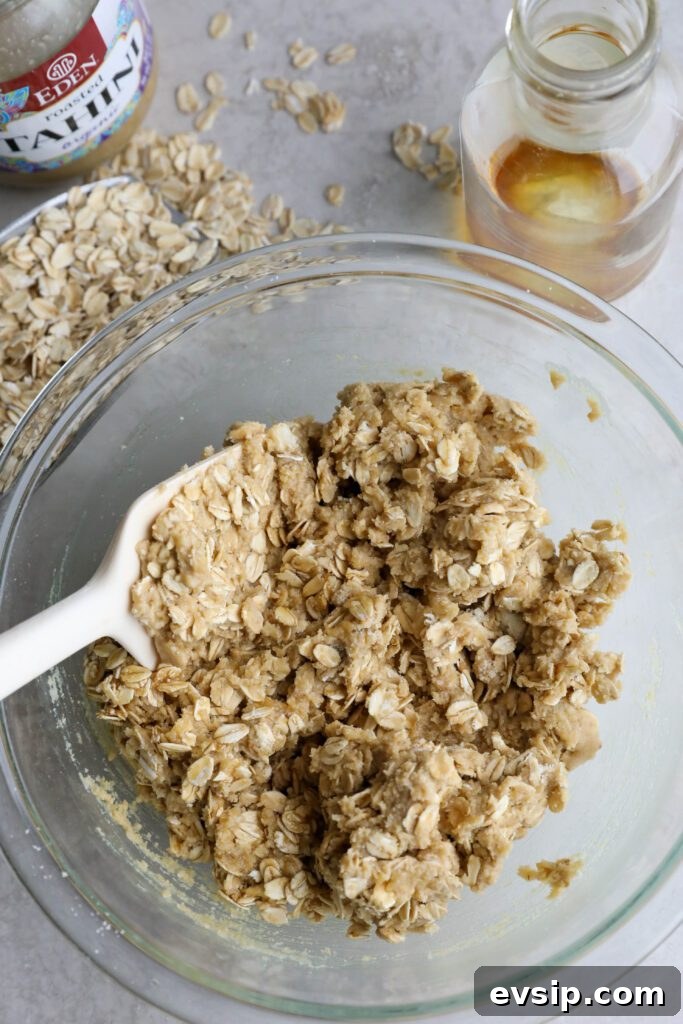 Apple Cherry Tahini Crumble Recipe — Rustic Fruit Dessert 8 crumble topping mixed in bowl with spatula