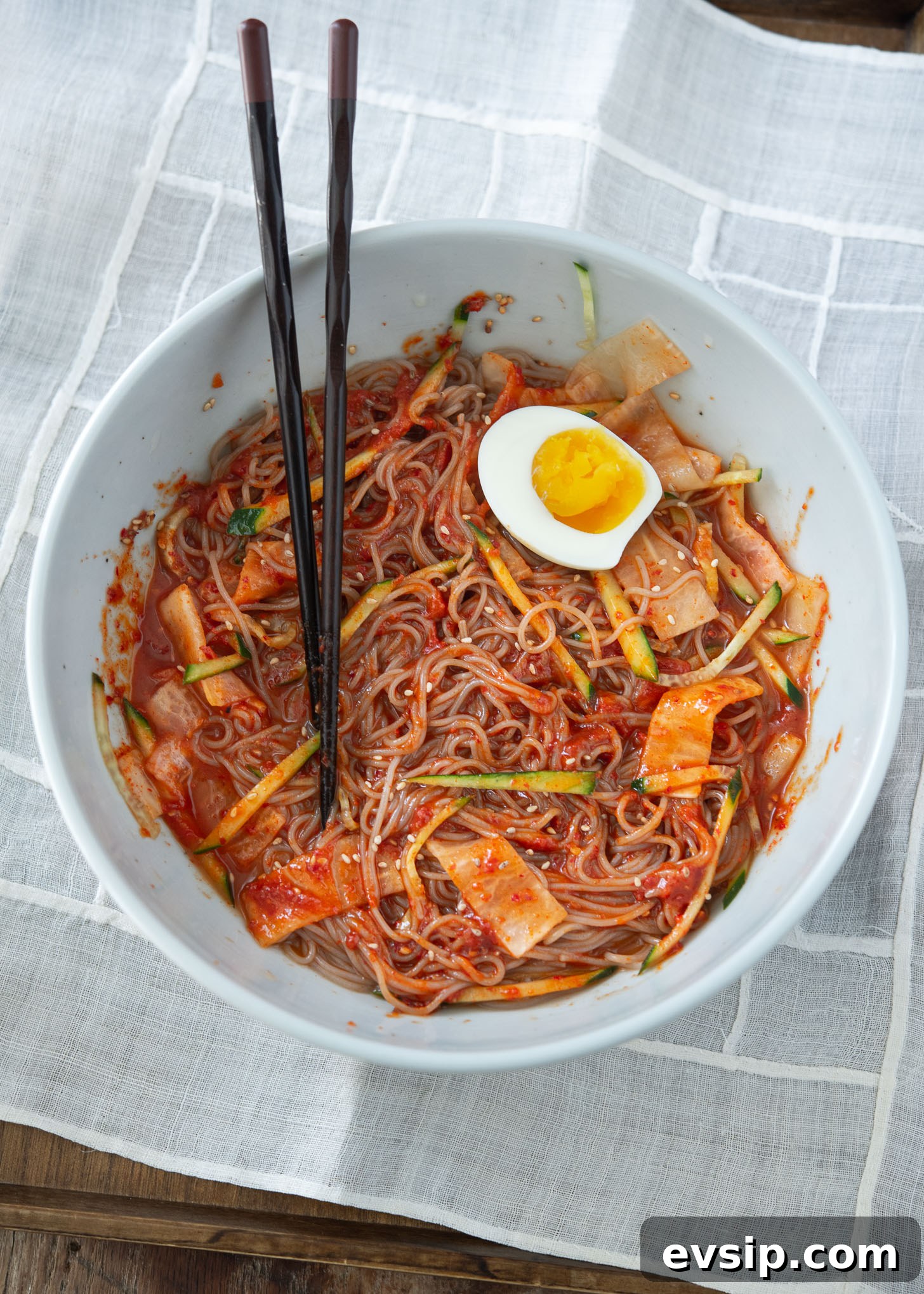 Korean cold buckwheat noodles tossed with spicy red chili sauce until fully coated.