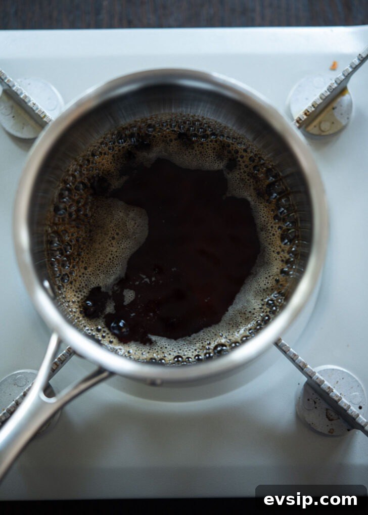 Bibim naengmyeon sauce base boiling in a pot to develop deep umami flavor.
