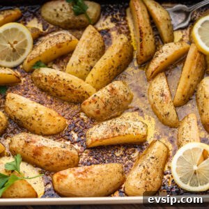 Lemon Oregano Roasted Greek Potatoes 6 Greek potatoes in large baking pan with lemon and parsley garnish.