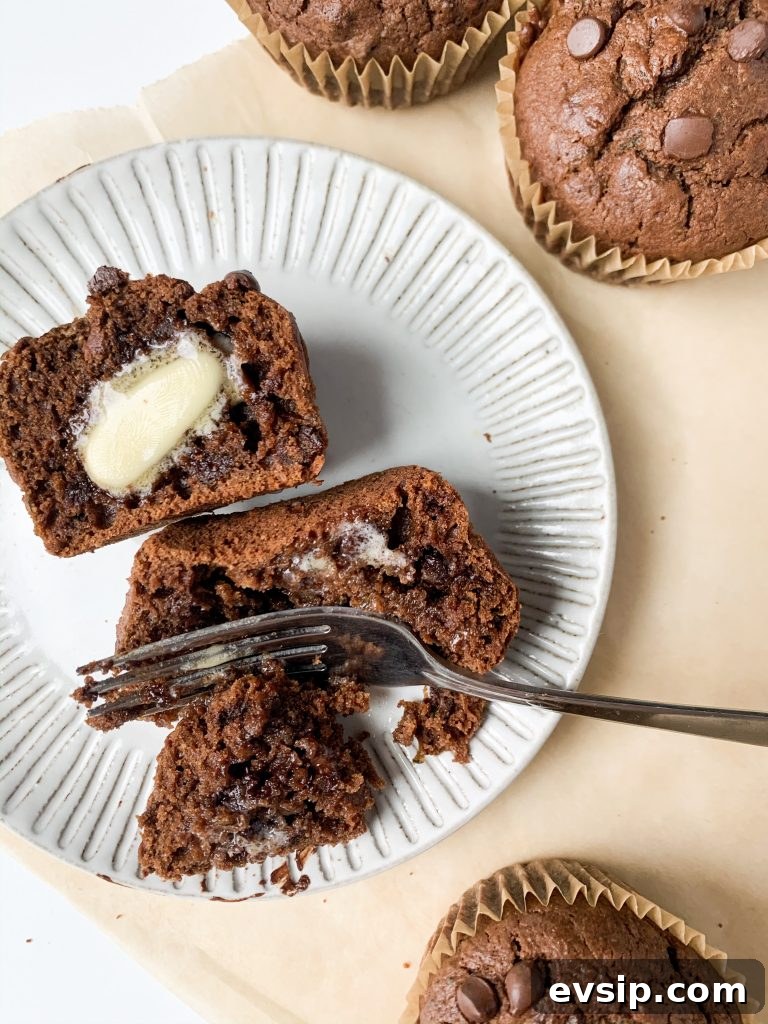 one double chocolate zucchini muffin on a plate with a fork taking a bite