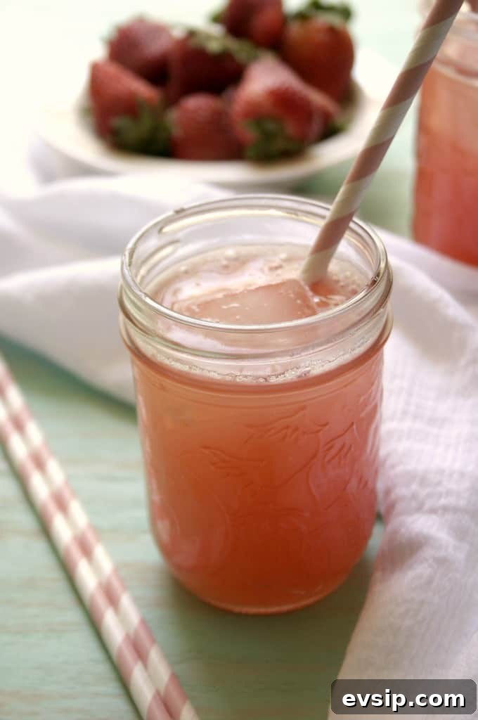 Strawberry Agua Fresca is easy and quick and completely satisfying. The perfect way to drink more water this summer. Side shot of glass jar with strawberry agua fresca.