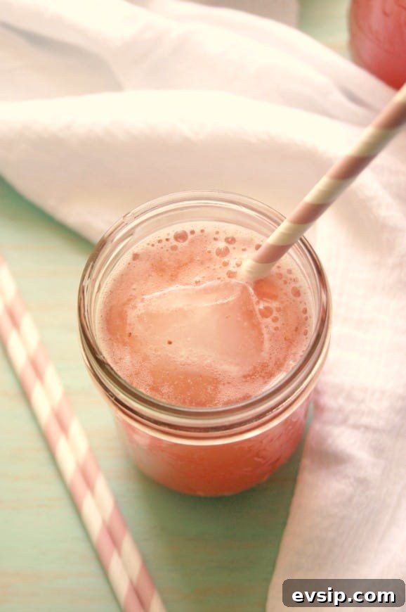 Strawberry Agua Fresca is easy and quick and completely satisfying. The perfect way to drink more water this summer. Overhead shot of strawberry agua fresca in glass jar with straw.