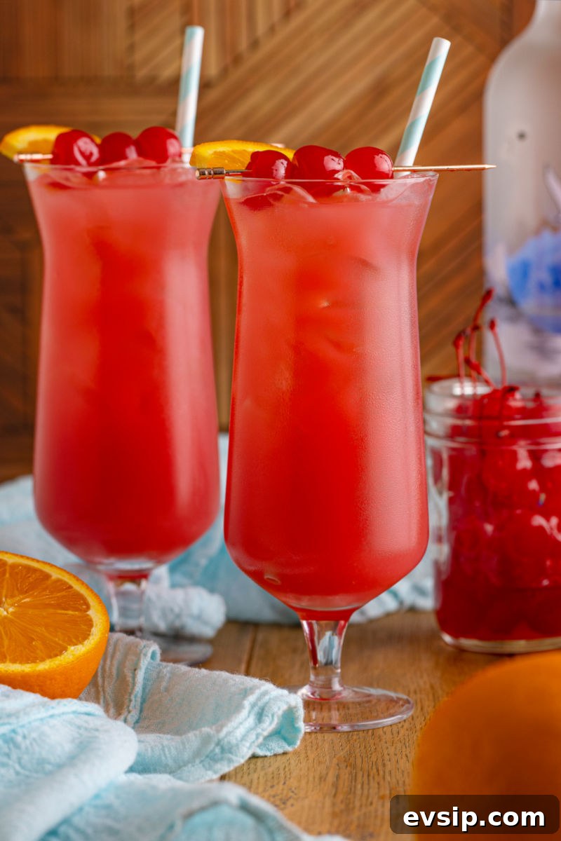 side view of two sex on the beach drinks in hurricane glasses