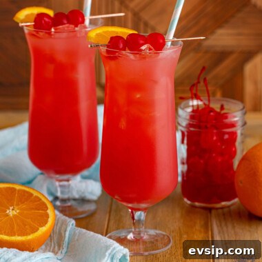 square image of two sex on the beach drinks next to an orange and bowl of cherries