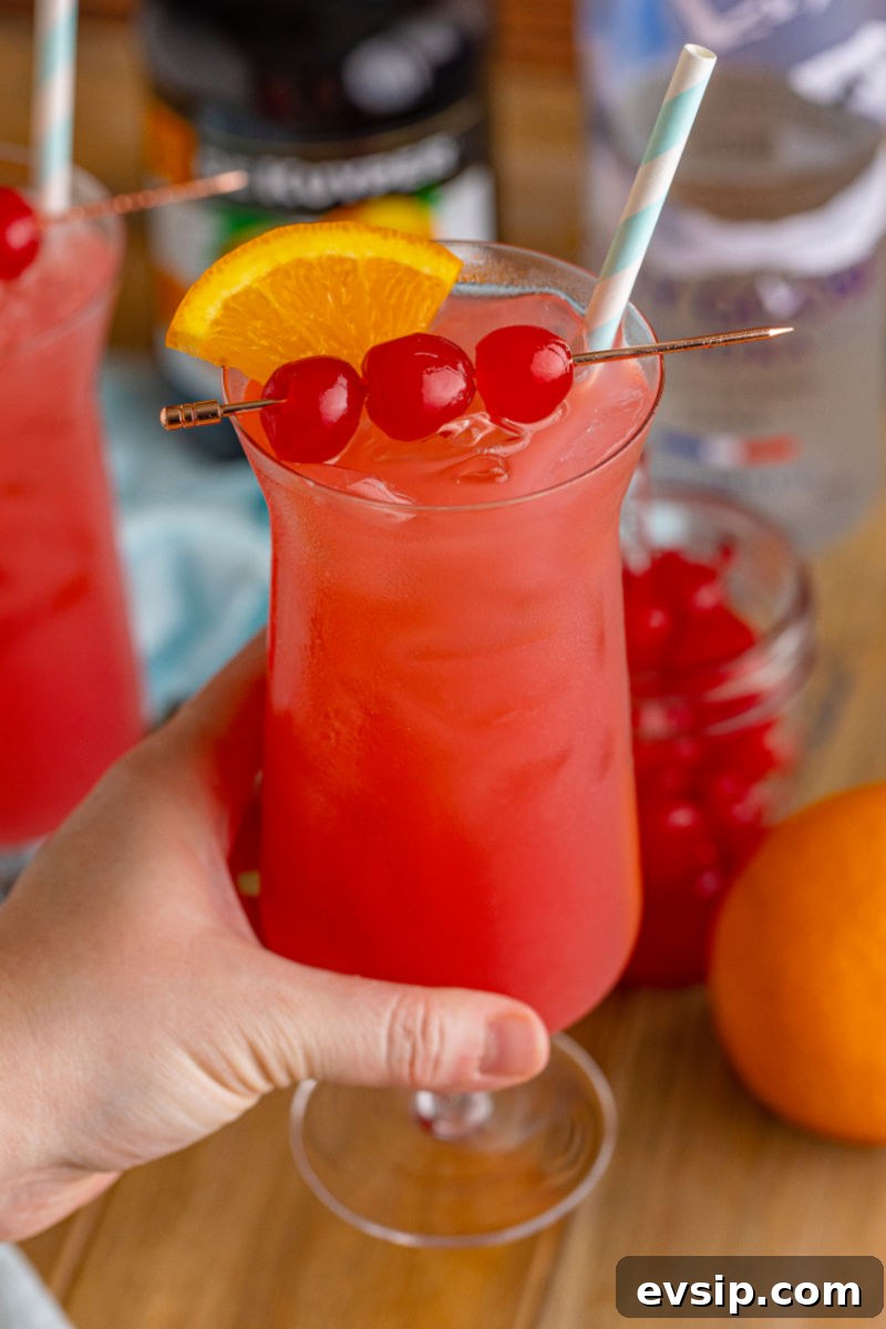 hand holding a sex on the beach in a hurricane glass