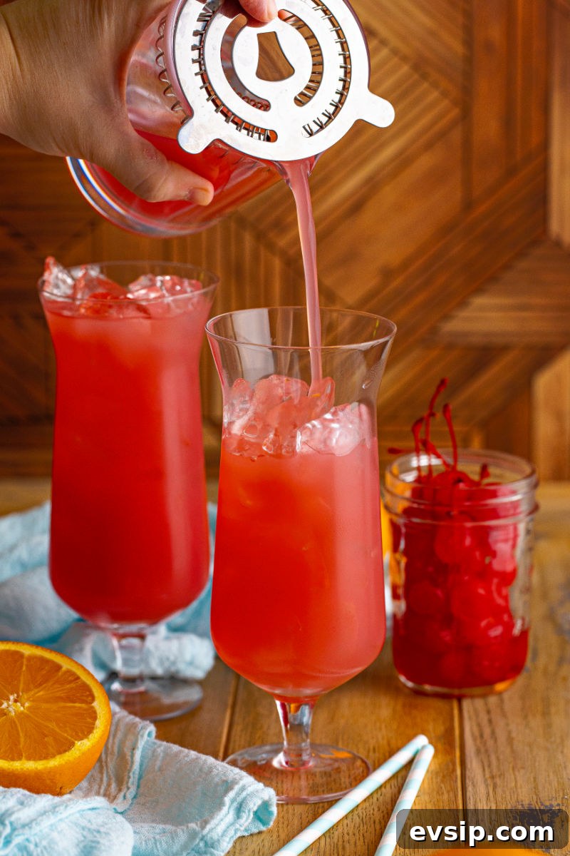 sex on the beach being strained into a hurricane glass filled with ice