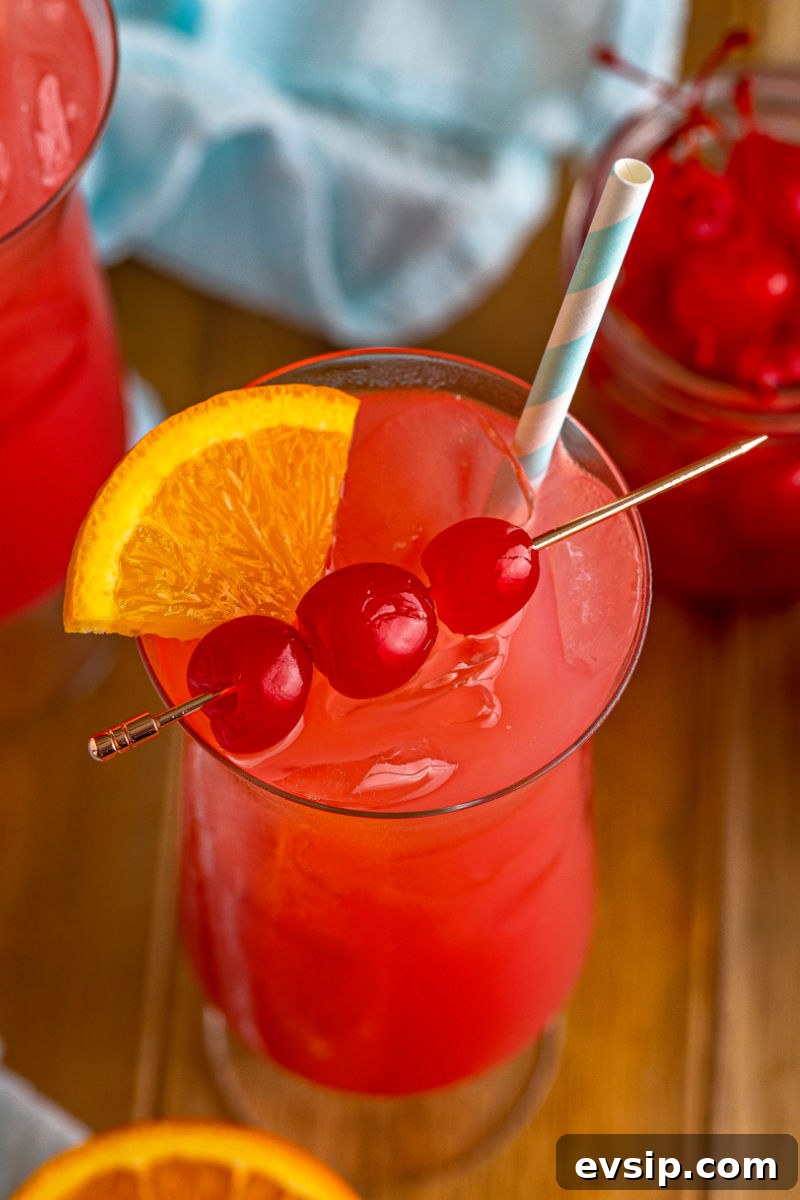 sex on the beach drink garnished with an orange slice wedge and maraschino cherries